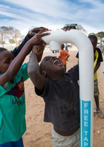 kind drinkt water uit een tappunt in Gambia